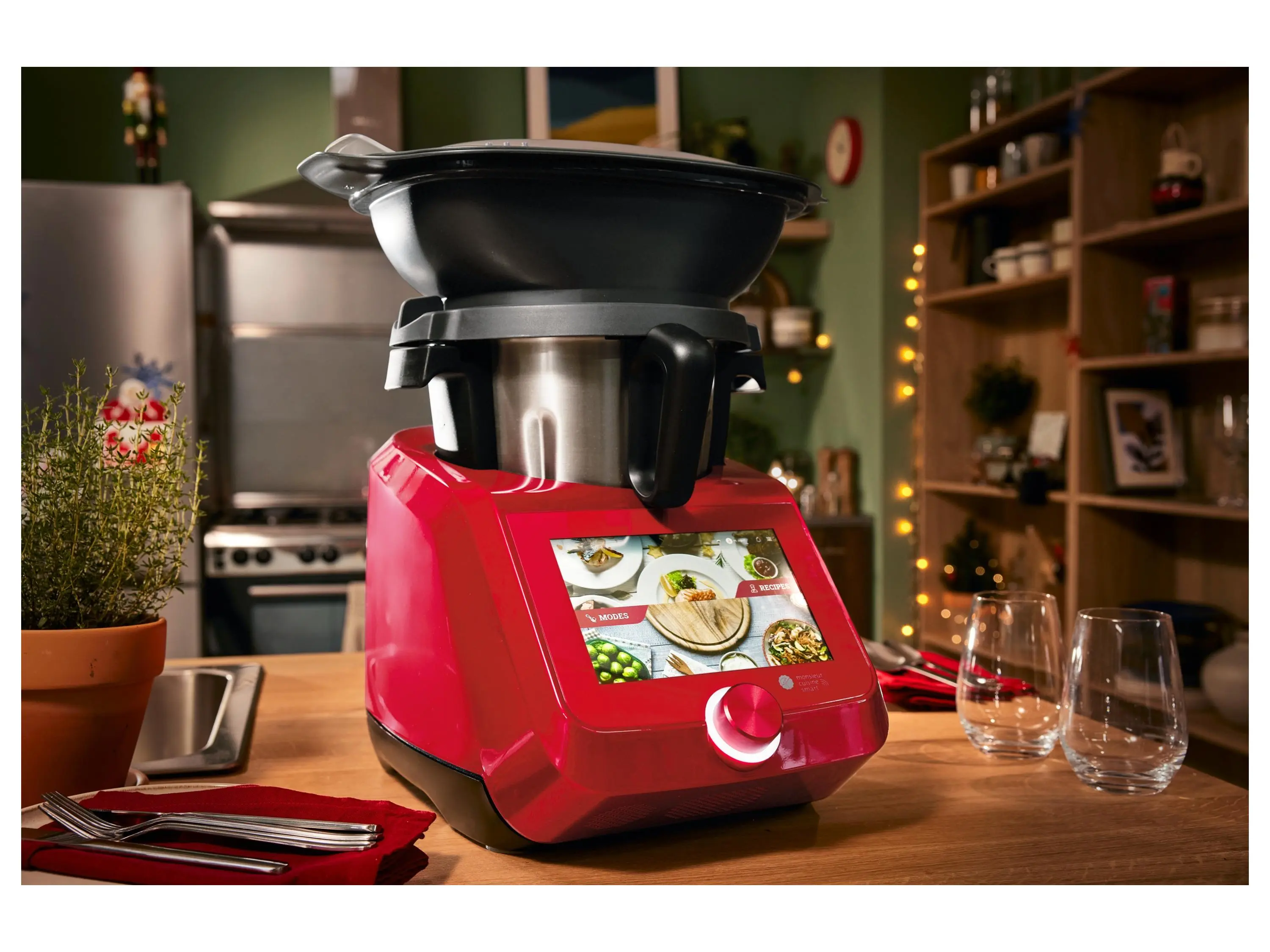 Küchenmaschine mit Kochfunktion in leuchtendem Rot auf Küchenarbeitsplatte, Touchscreen display und Deckel mit Mixeraufsatz, stilvolles Küchenumfeld.